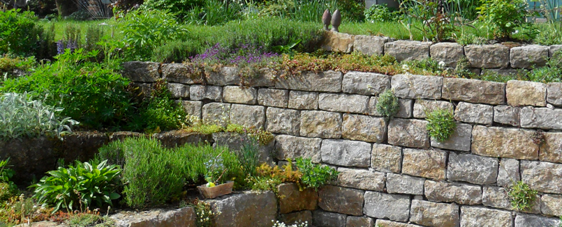 Bepflanzte Naturstein-Trockenmauer zur Hangbefestigung